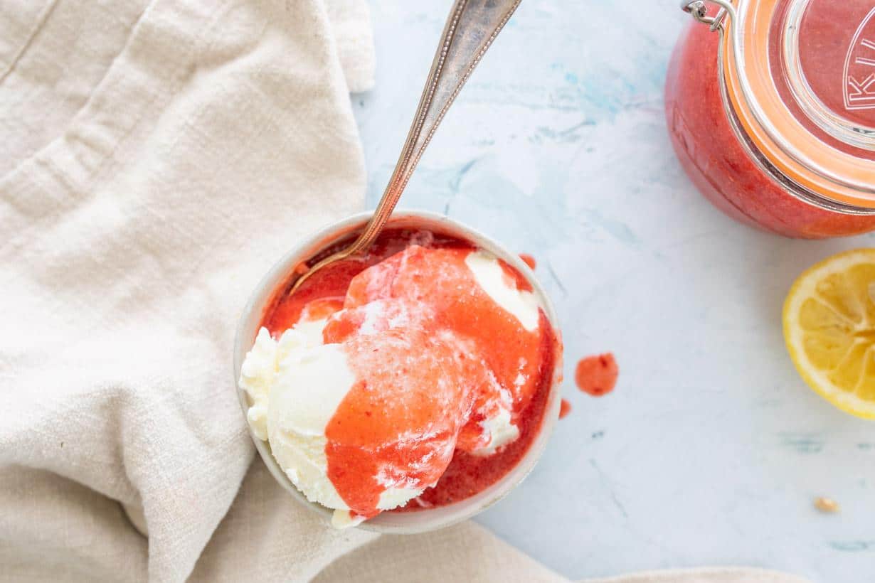 ice cream in a bowl with fresh strawberry sauce on top
