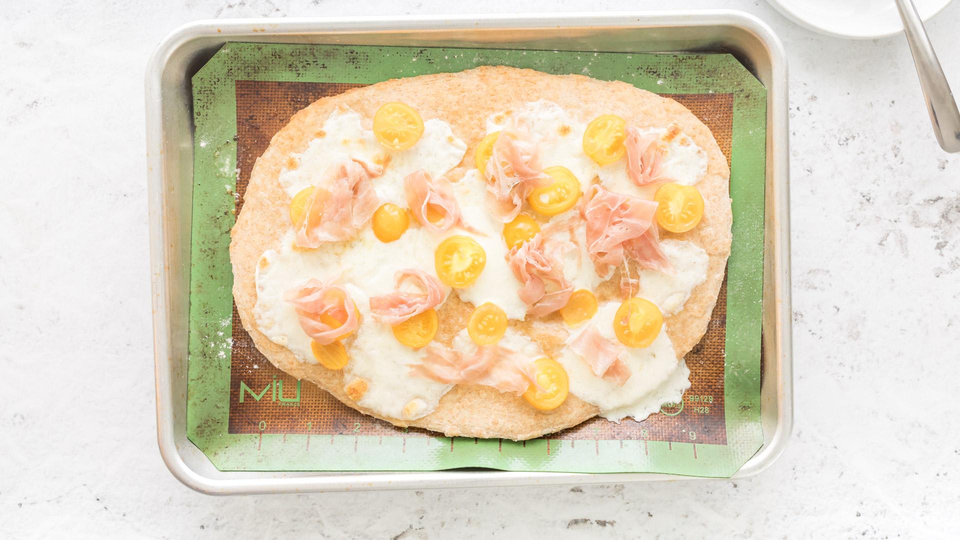 cooked pizza caprese on a baking sheet