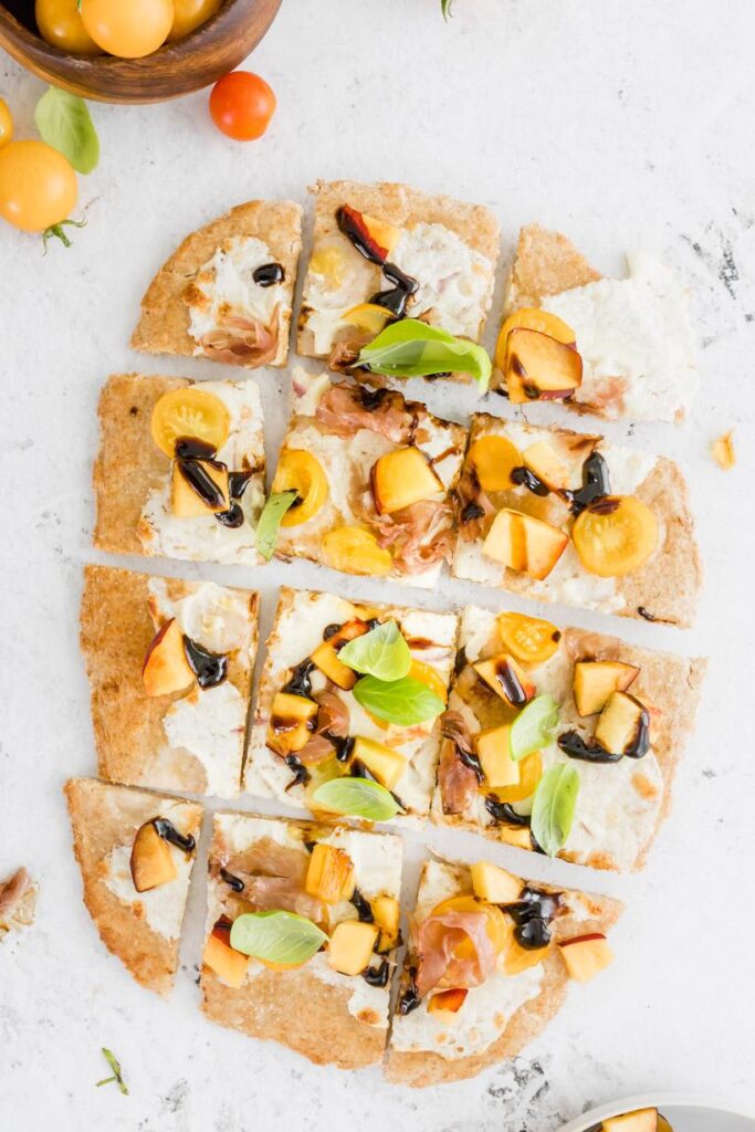 peach and prosciutto pizza on a table