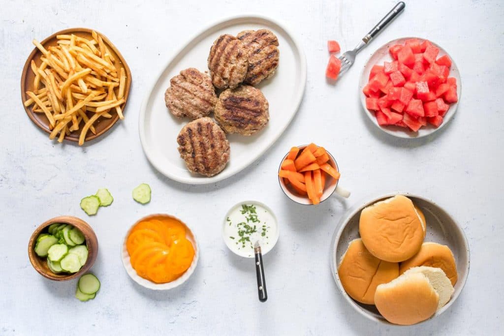 spiced lamb burgers and toppings on a table