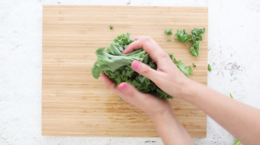 hands massaging kale