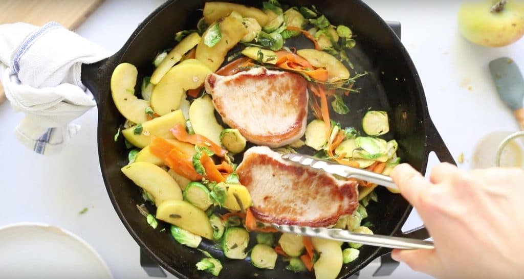 pan fried pork chops with apples in cast iron skillet