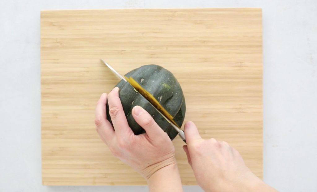 cutting acorn squash on a cutting board