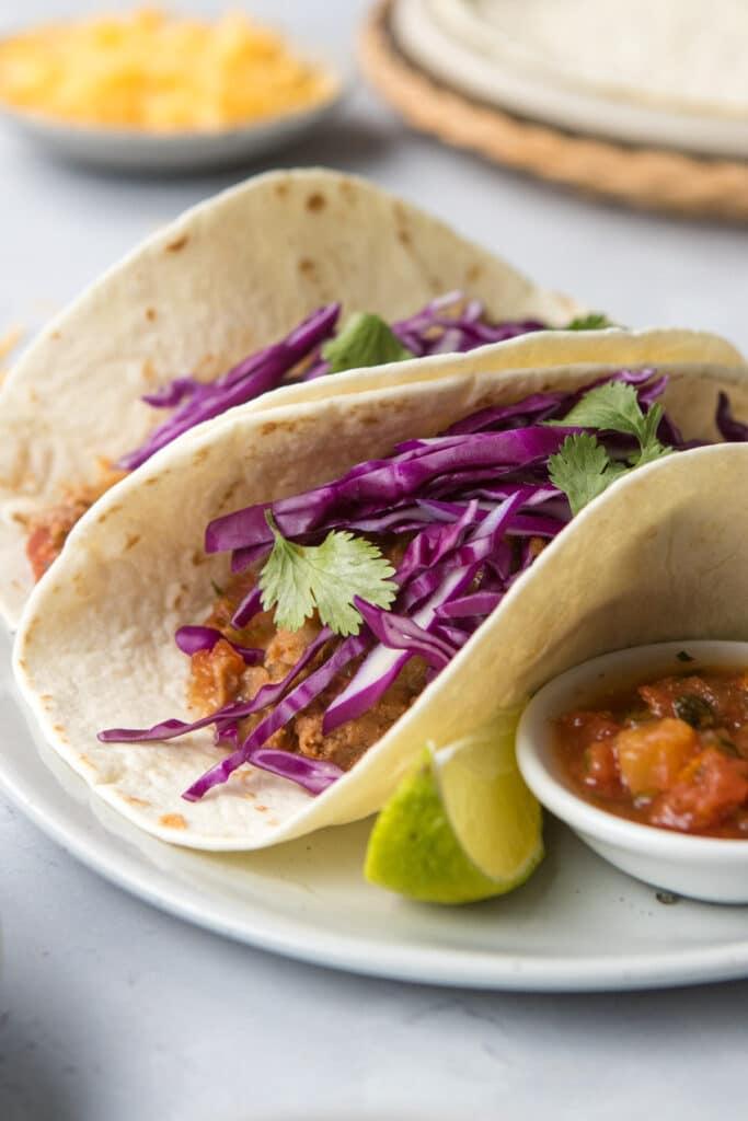 close up of refried beans, red cabbage, and cilantro taco