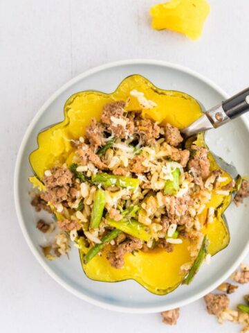 stuffed acorn squash recipe with a fork in it, on a plate