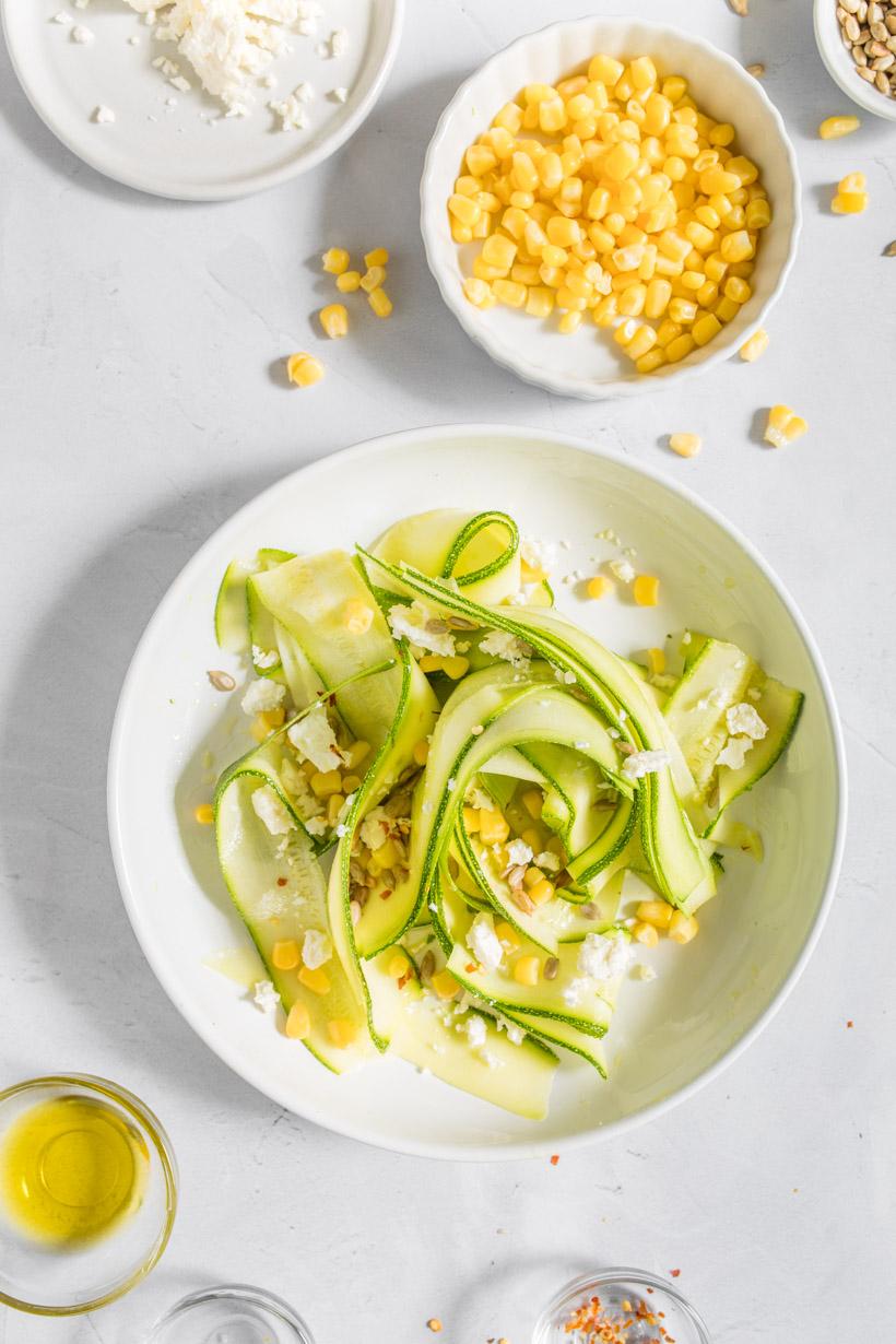 zucchini salad with feta on a table with ingredients