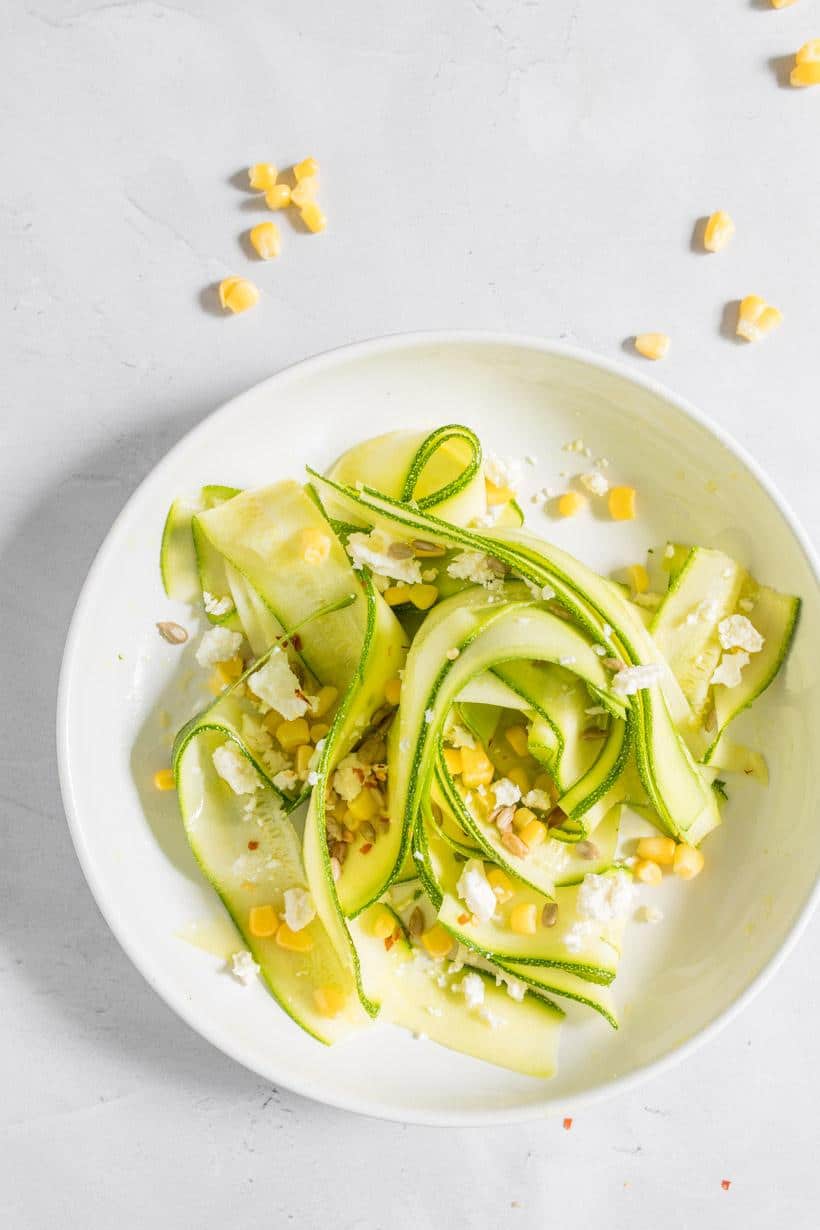 raw zucchini salad with feta in a bowl