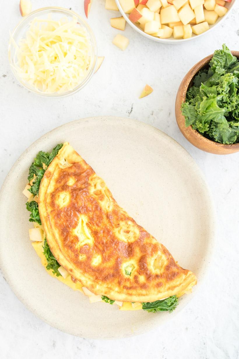 apple omelette on a plate with ingredients on the table