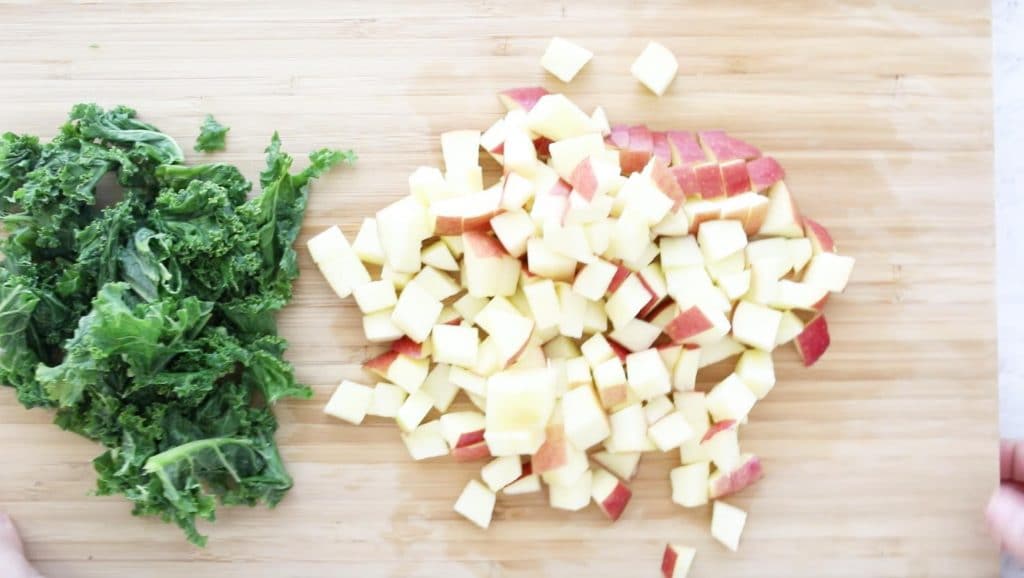chopped kale and apples on a cutting board
