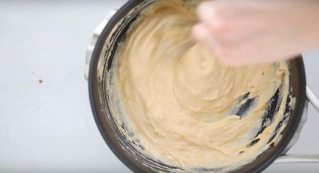 stirring queso dip in a pot