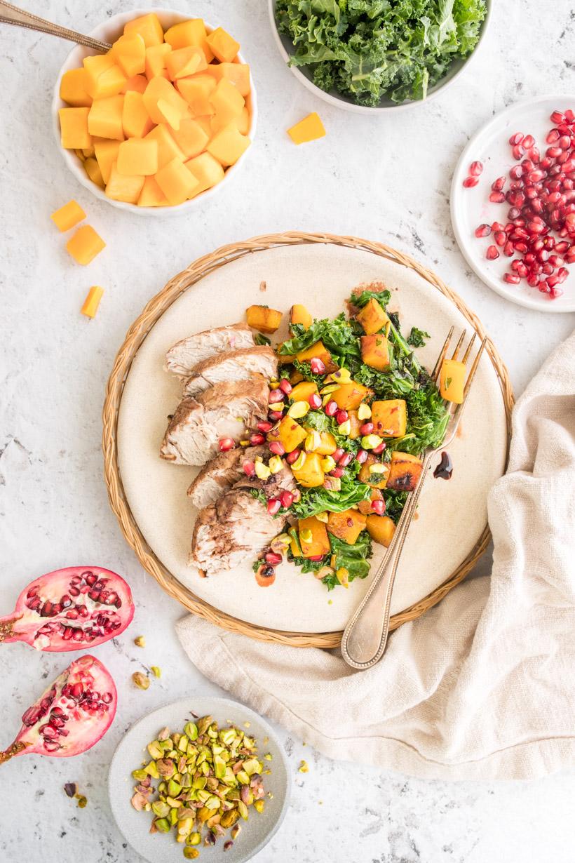 warm salad on a plate with ingredients surrounding it on a table