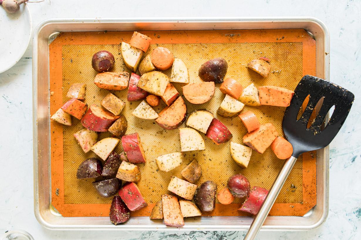 chopped vegetables with herbs on a baking sheet