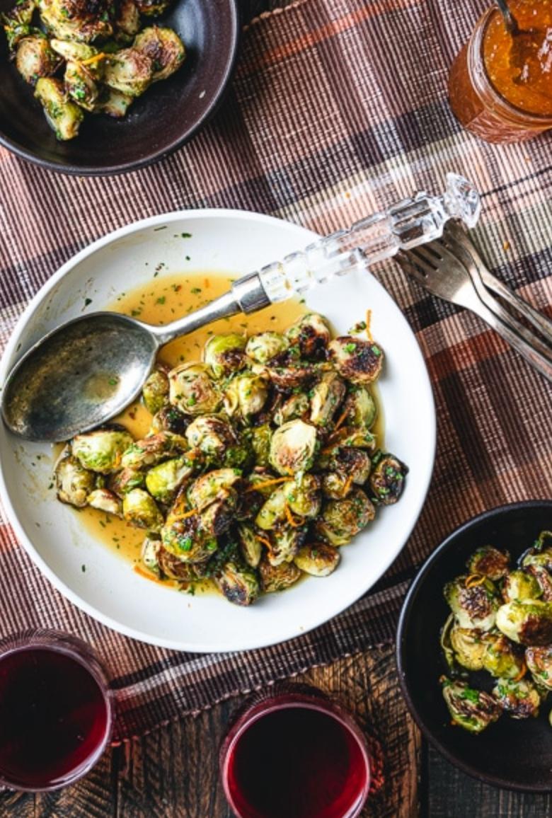 cooked brussels sprouts on a white plate with a spoon on the plate