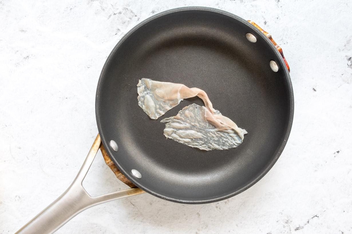 one slice of prosciutto in a small fry pan