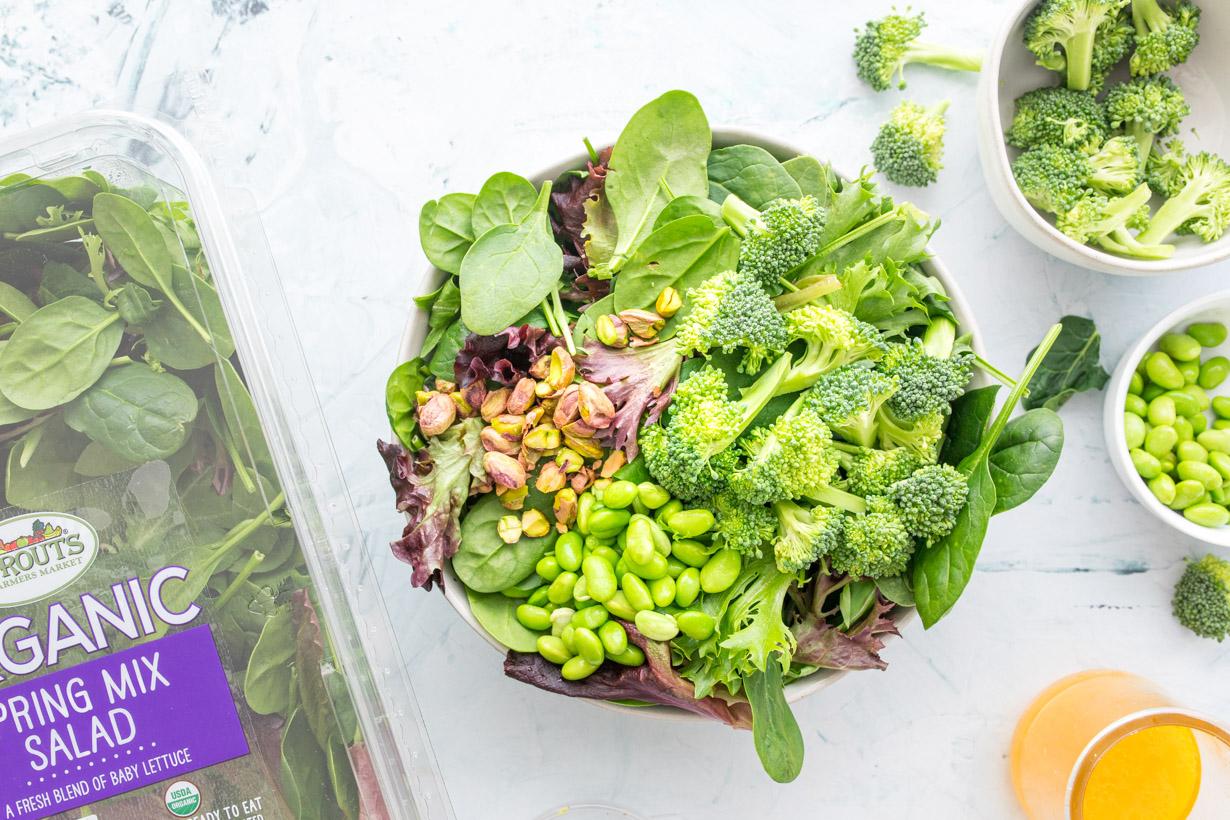 greens, edamame, pistachios, and broccoli in a bowl