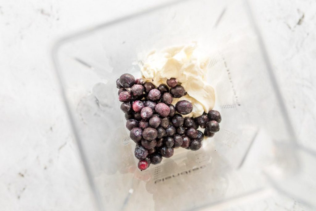 yogurt and frozen blueberries in a blender bowl