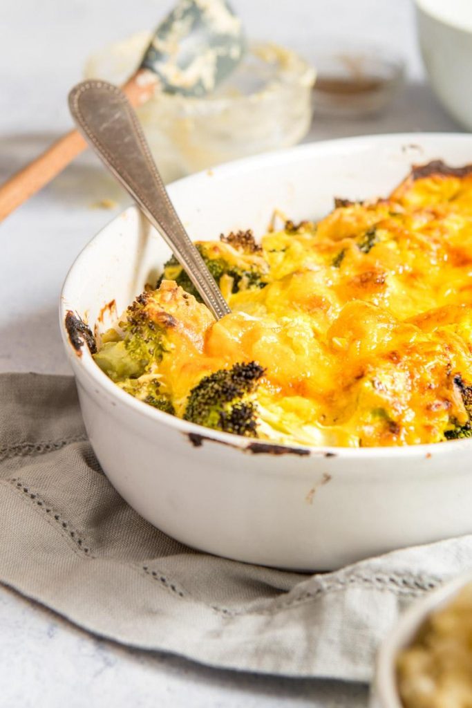 chicken broccoli divan in a white baking dish with a spoon in it