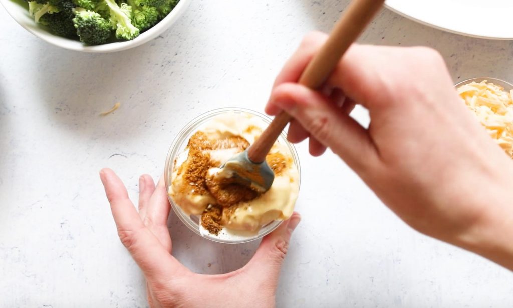 mixing cream of chicken sauce for chicken and broccoli divan in a small mixing bowl