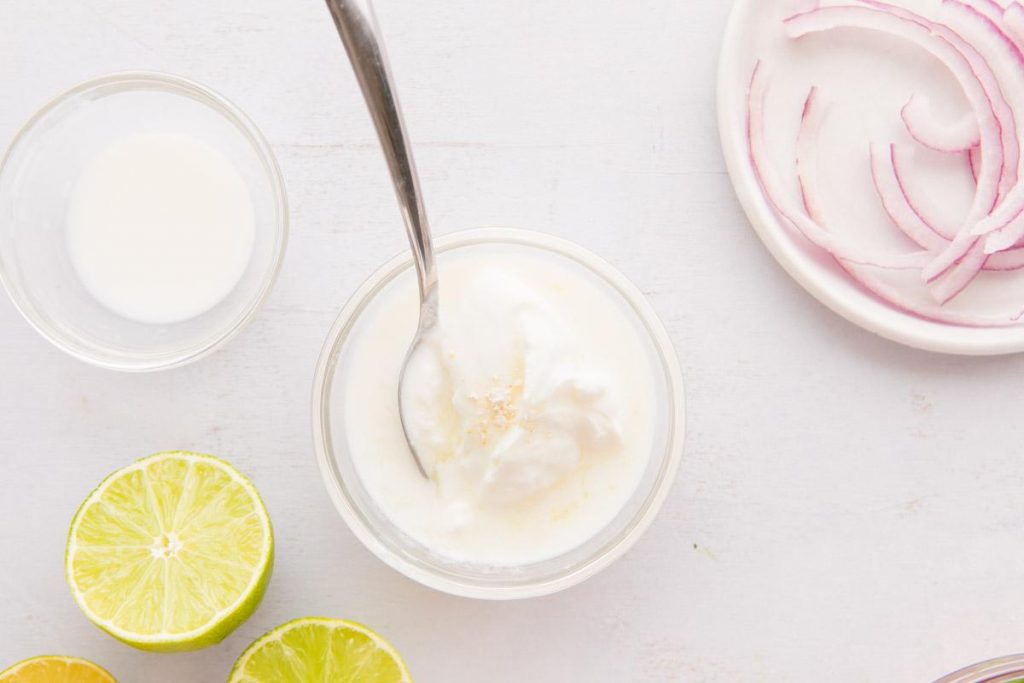 white sauce in a glass bowl with ingredients surrounding it