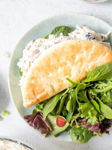 pita filled with chicken salad and salad on plate