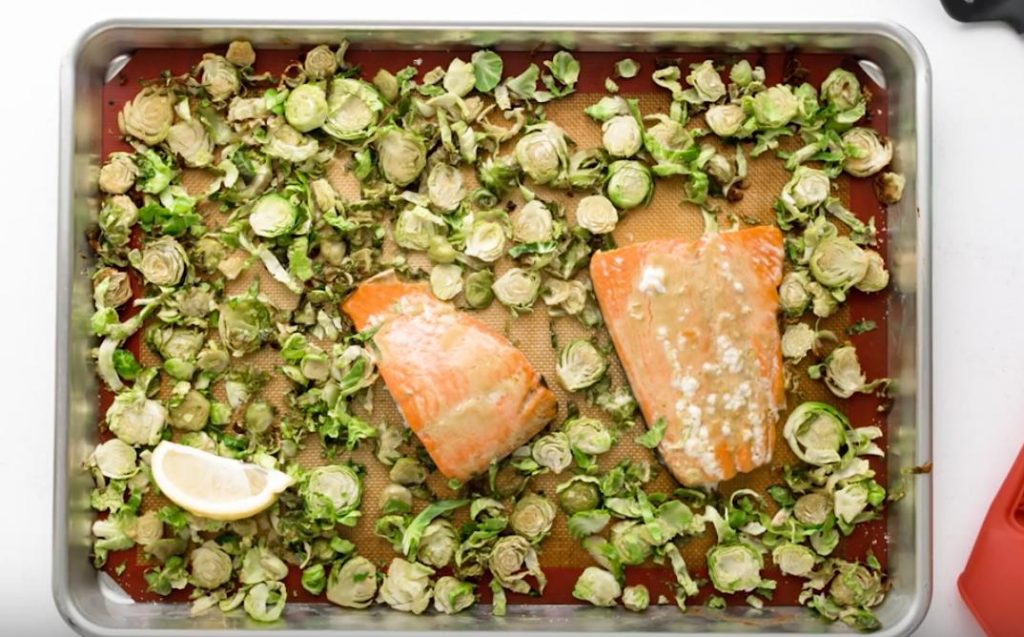 baked maple mustard salmon and brussels sprouts on a cookie sheet