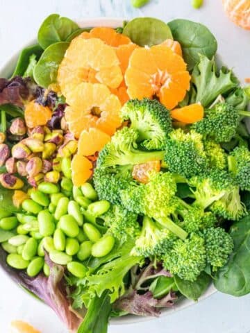 oranges, broccoli, edamame, nuts in bowl