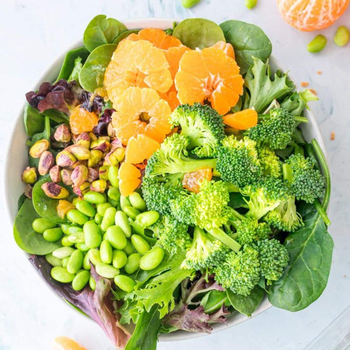 oranges, broccoli, edamame, nuts in bowl