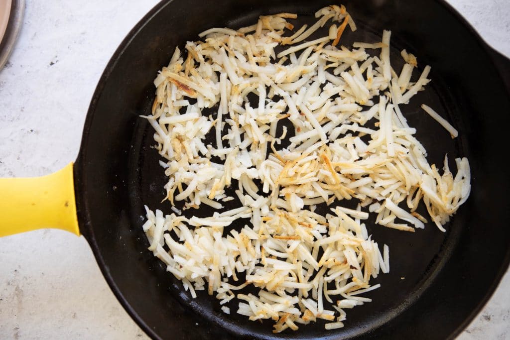 cooked hash browns in a cast iron skillet