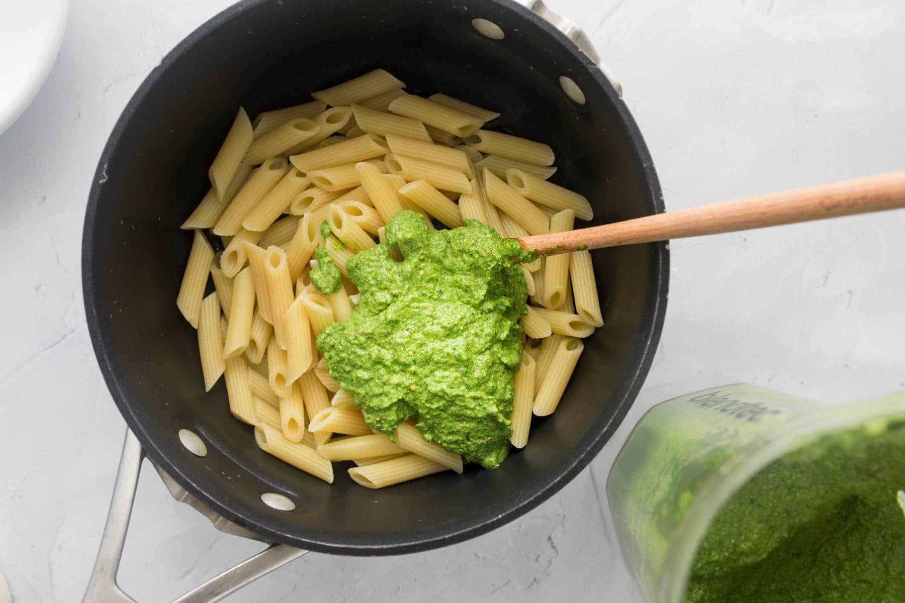 pesto over pasta in a black pot