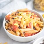 black bean pasta in a white bowl with ingredients around it