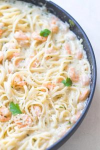 shrimp scampi alfredo with cilantro on top, in a skillet