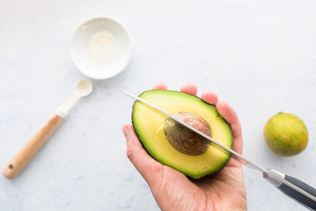 holding knife in the pit of an avocado