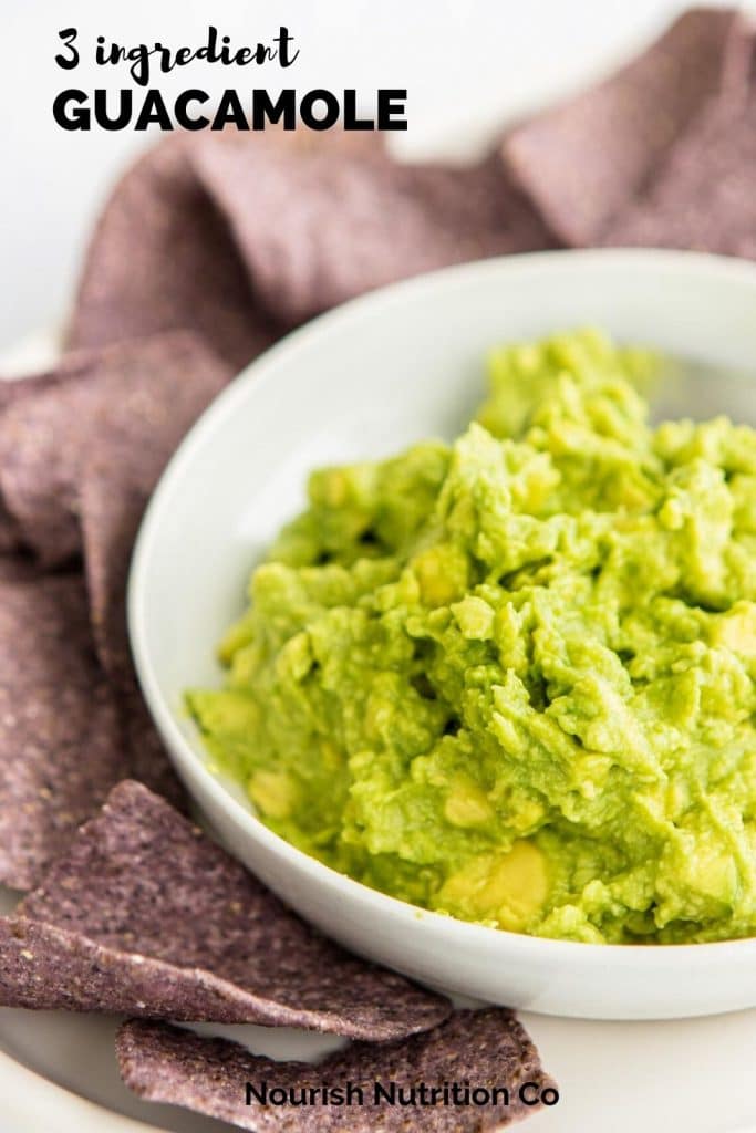 close up shot of guacamole in a bowl surrounded with blue chips and text overlay