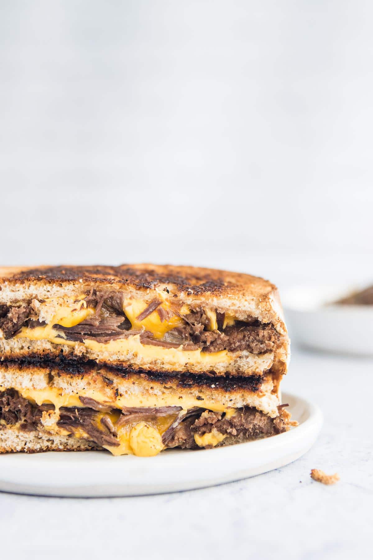 open slices of brisket grilled cheese on a plate