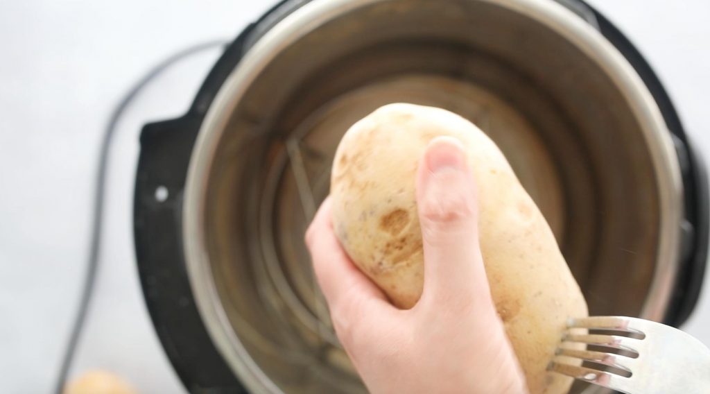 piercing a potato with a fork