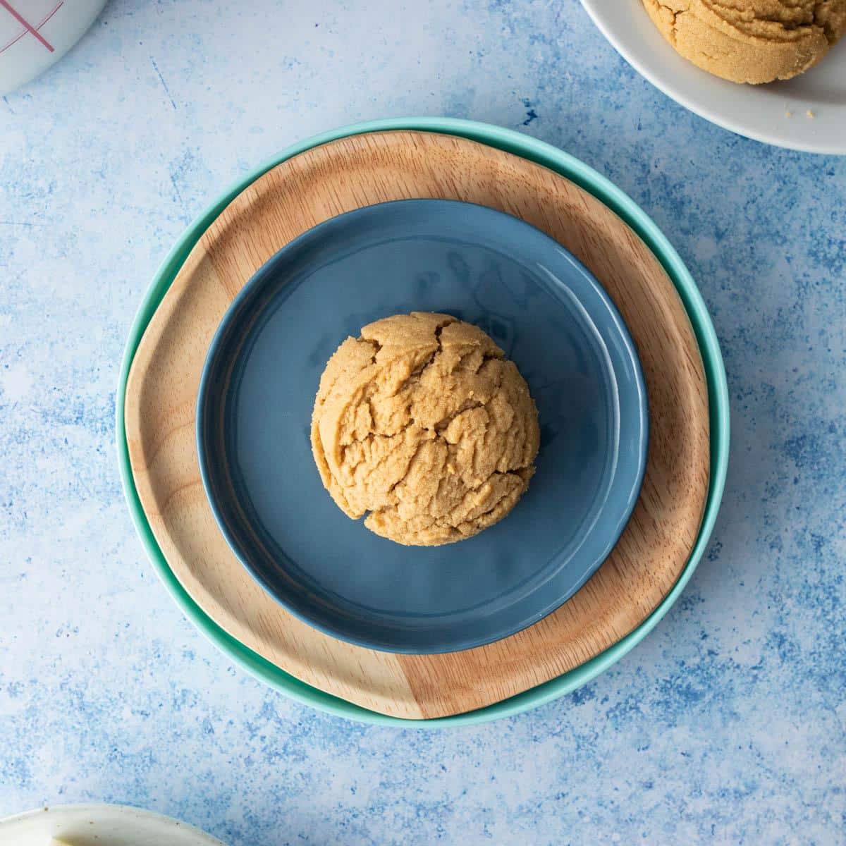 one peanut butter cookie on blue and wooden plates