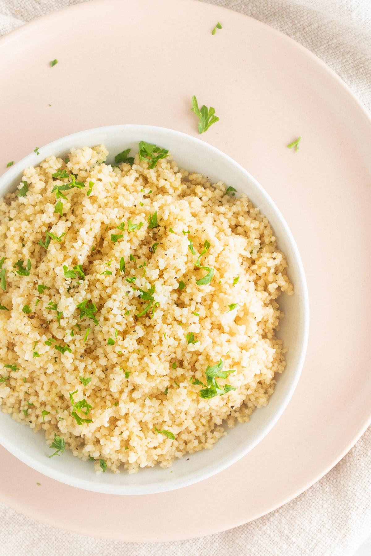 couscous with herbs on a pink plate