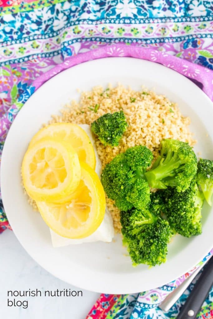 cod with lemon on top next to couscous and broccoli with text overlay