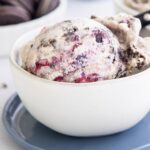 a scoop of blueberry oreo ice cream in a cream bowl