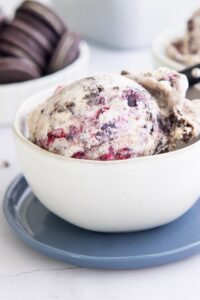 a scoop of blueberry oreo ice cream in a cream bowl