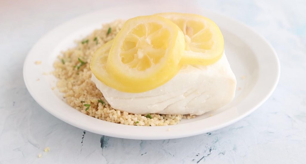 cod with lemon slices on top on a plate