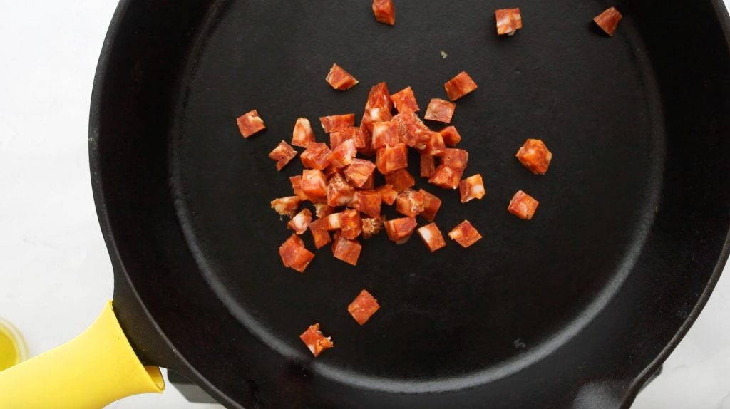 cubed salami in a cast iron skillet