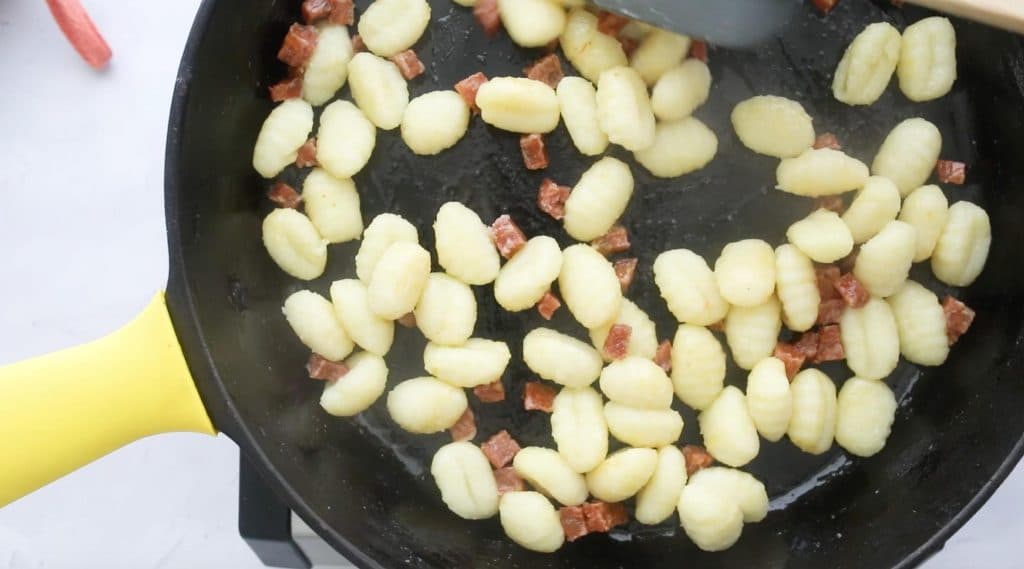 gnocchi and salami in a cast iron skillet