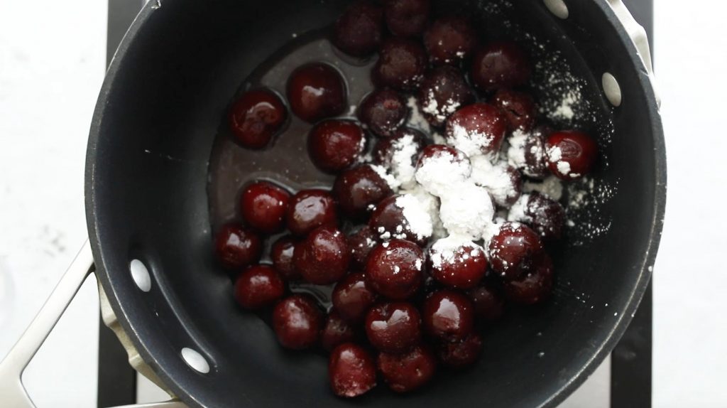 cooking cherries and cornstarch in a black pot