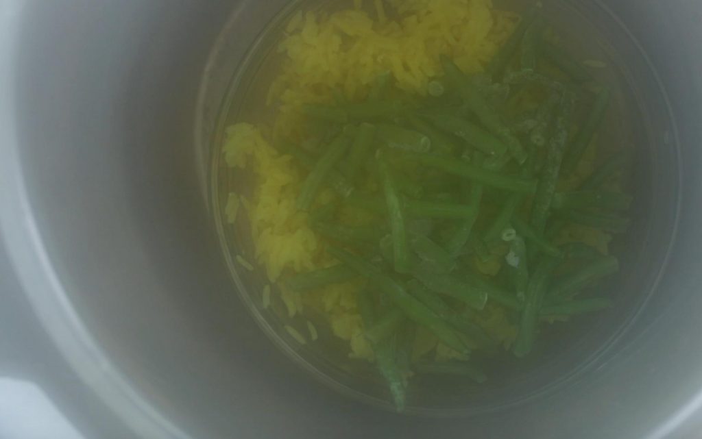 green beans over yellow rice with steam