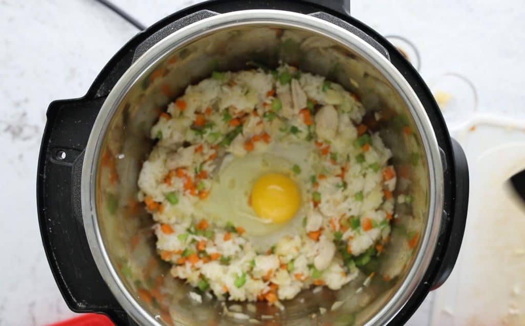 instant pot bowl with chicken fried rice and a cracked egg in the middle