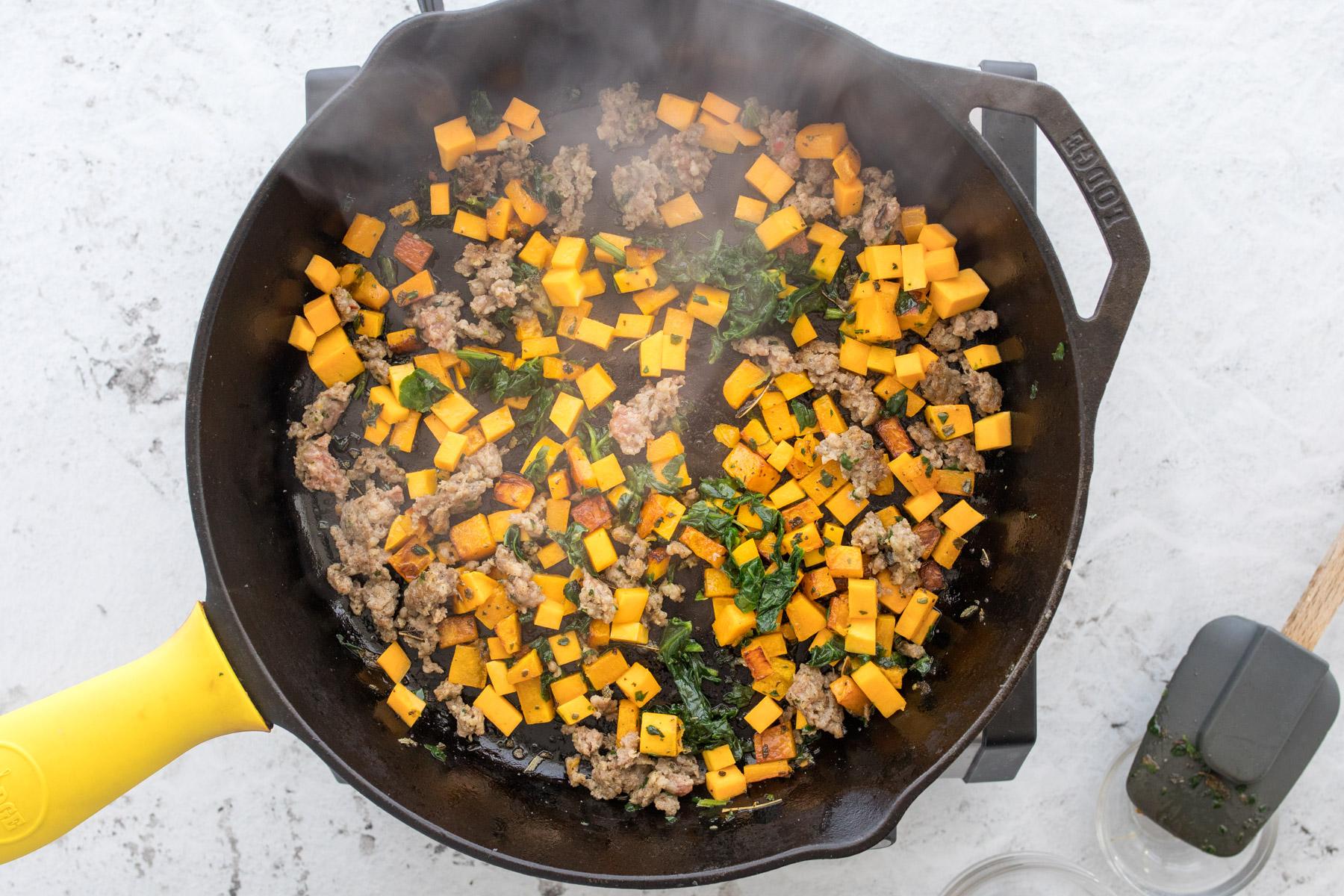 butternut squash, sausage, and spinach in skillet