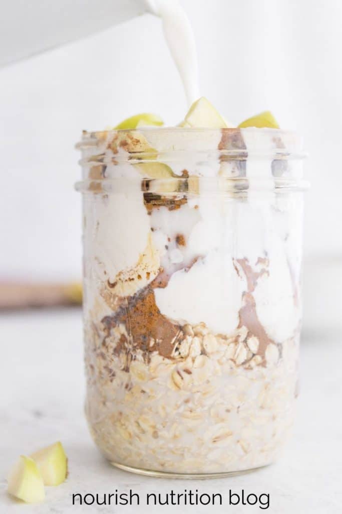 pouring milk into a glass jar of overnight oats with text overlay