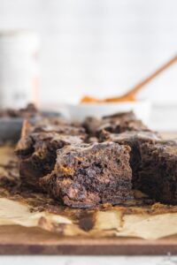 cut pumpkin swirl brownie with ingredients in the back