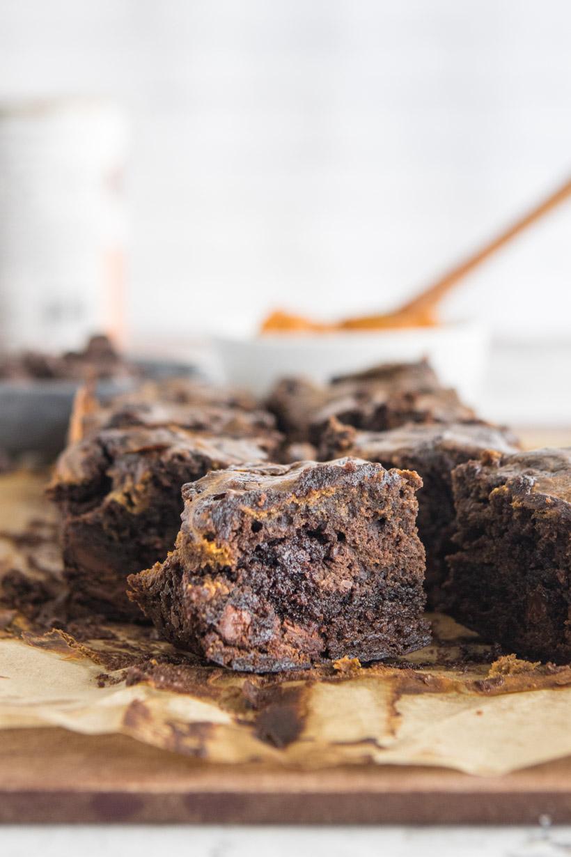 cut pumpkin swirl brownie with ingredients in the back